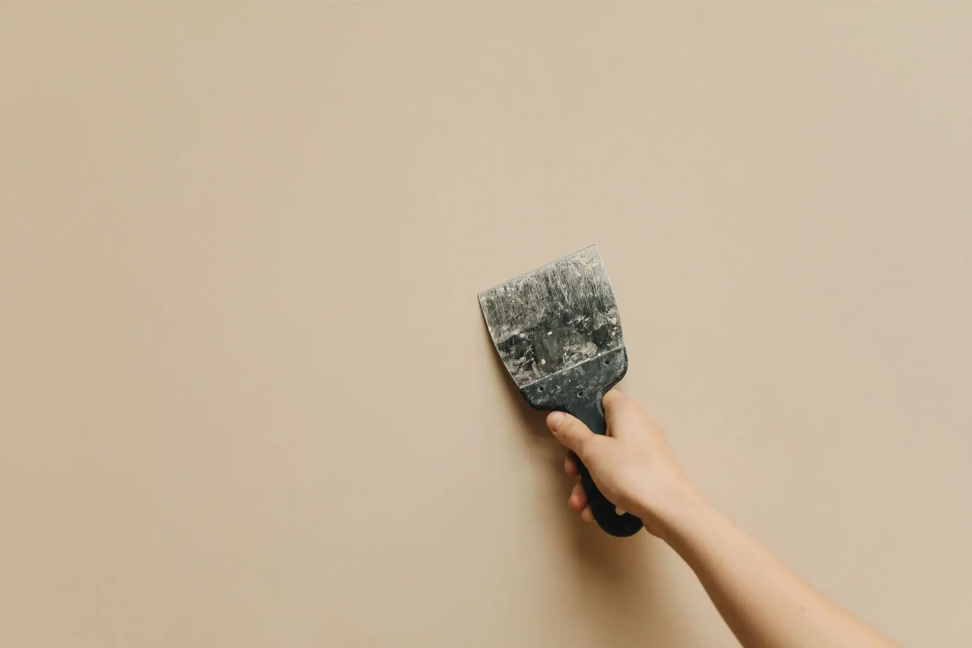 Roller applying fresh white paint to a ceiling